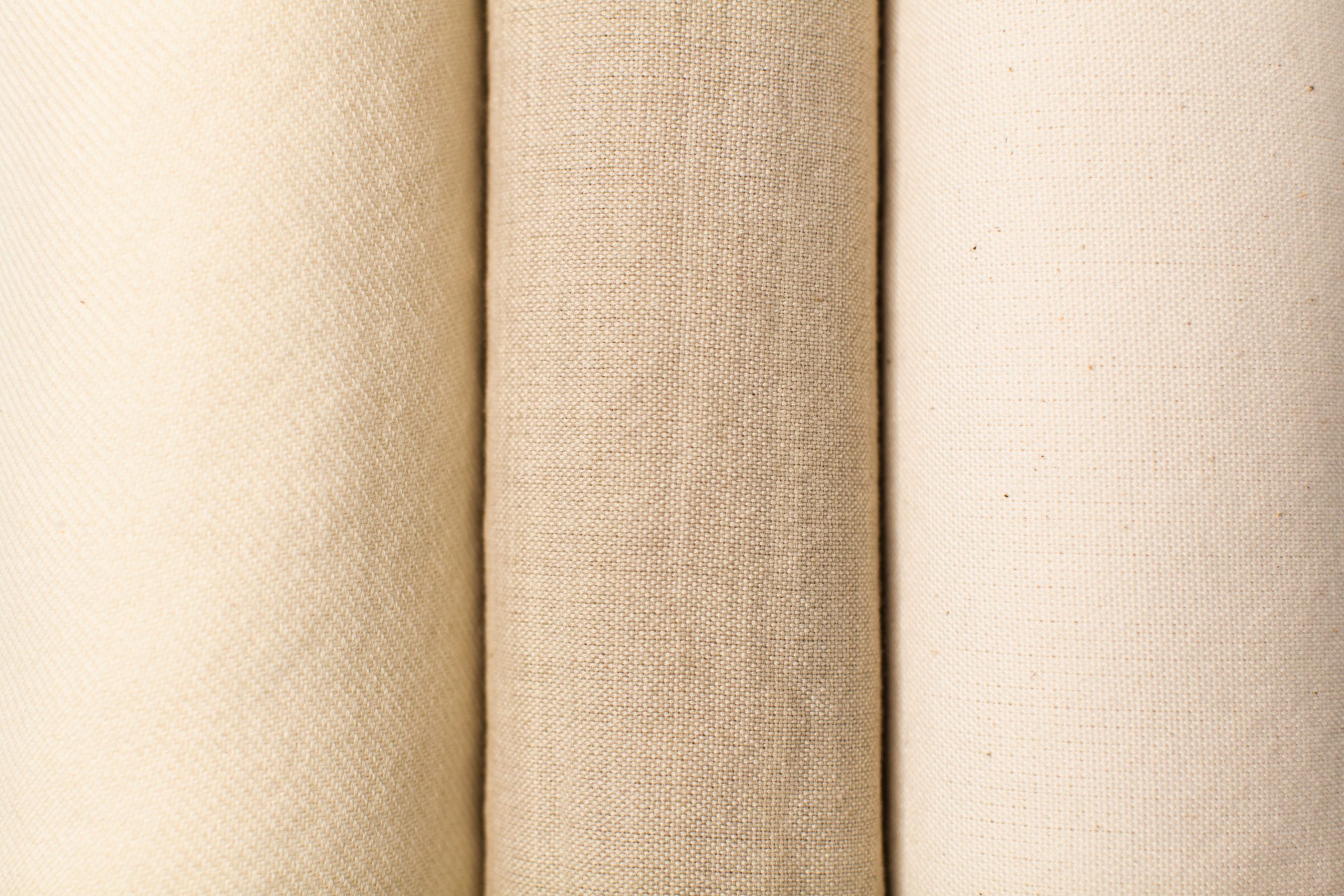 photograph of three cream colored woven textiles close up