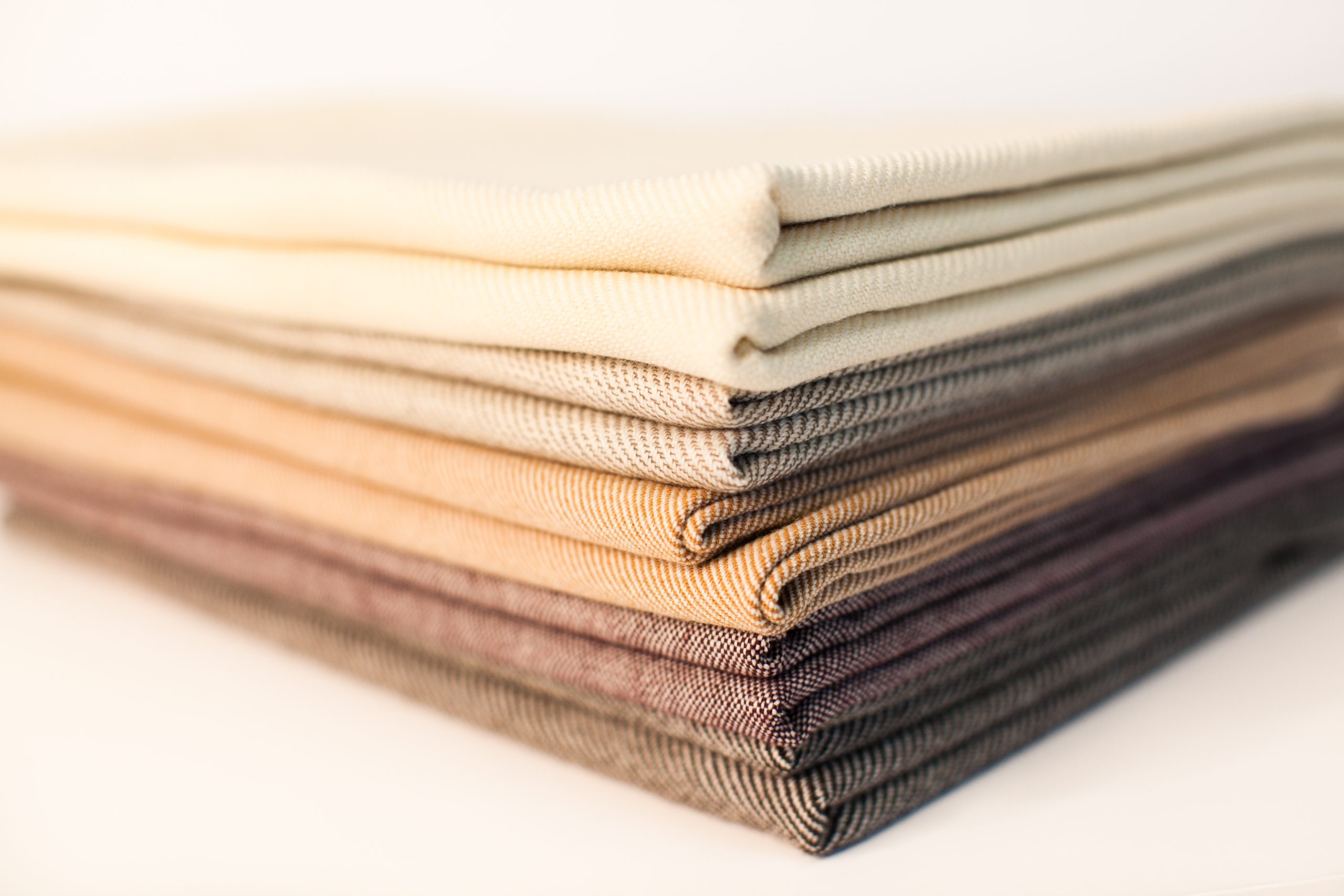 detailed photograph of multiple earth tone wool and cotton textiles stacked